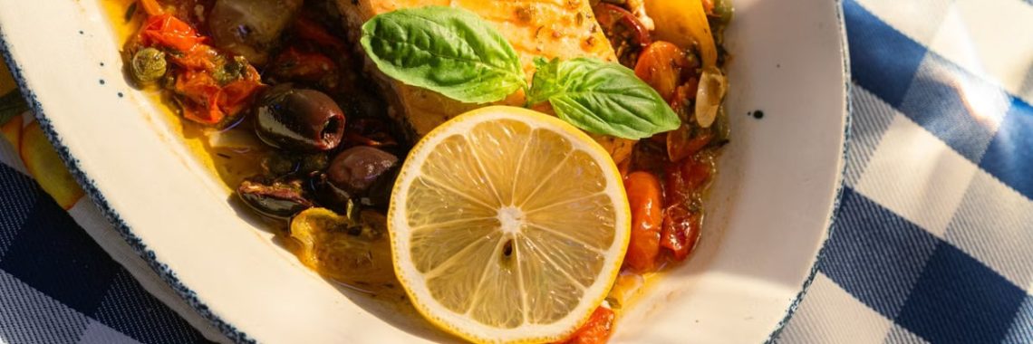 Delicious grilled salmon topped with lemon and basil on a sunlit table.